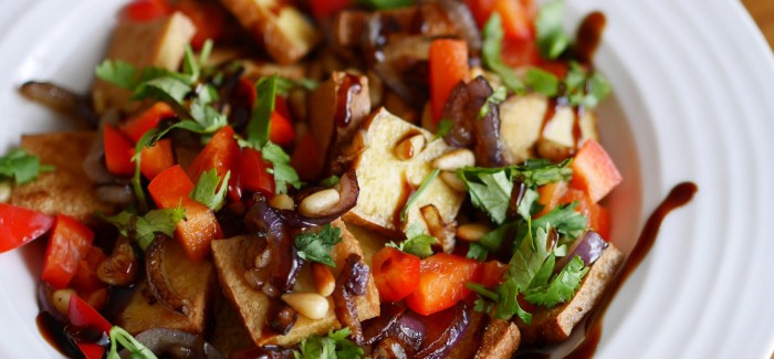 Salade tiède de tofu fumé, poivrons croquants, oignons caramélisés et pignons grillés